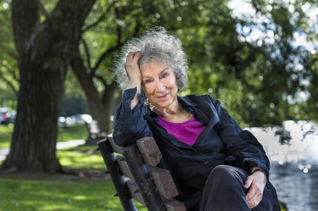Margaret Atwood sitting sideways on a park bench