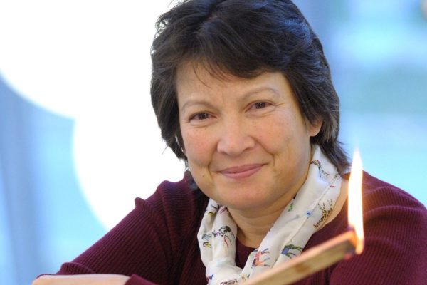 Head and shoulders of Tami Bond holding a burning stick