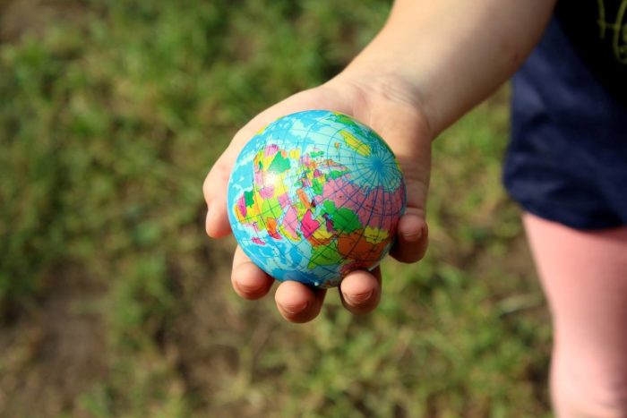 Close up of a person holding a globe of the world in their hand