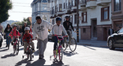 Street view showing a group of adults and children cycling