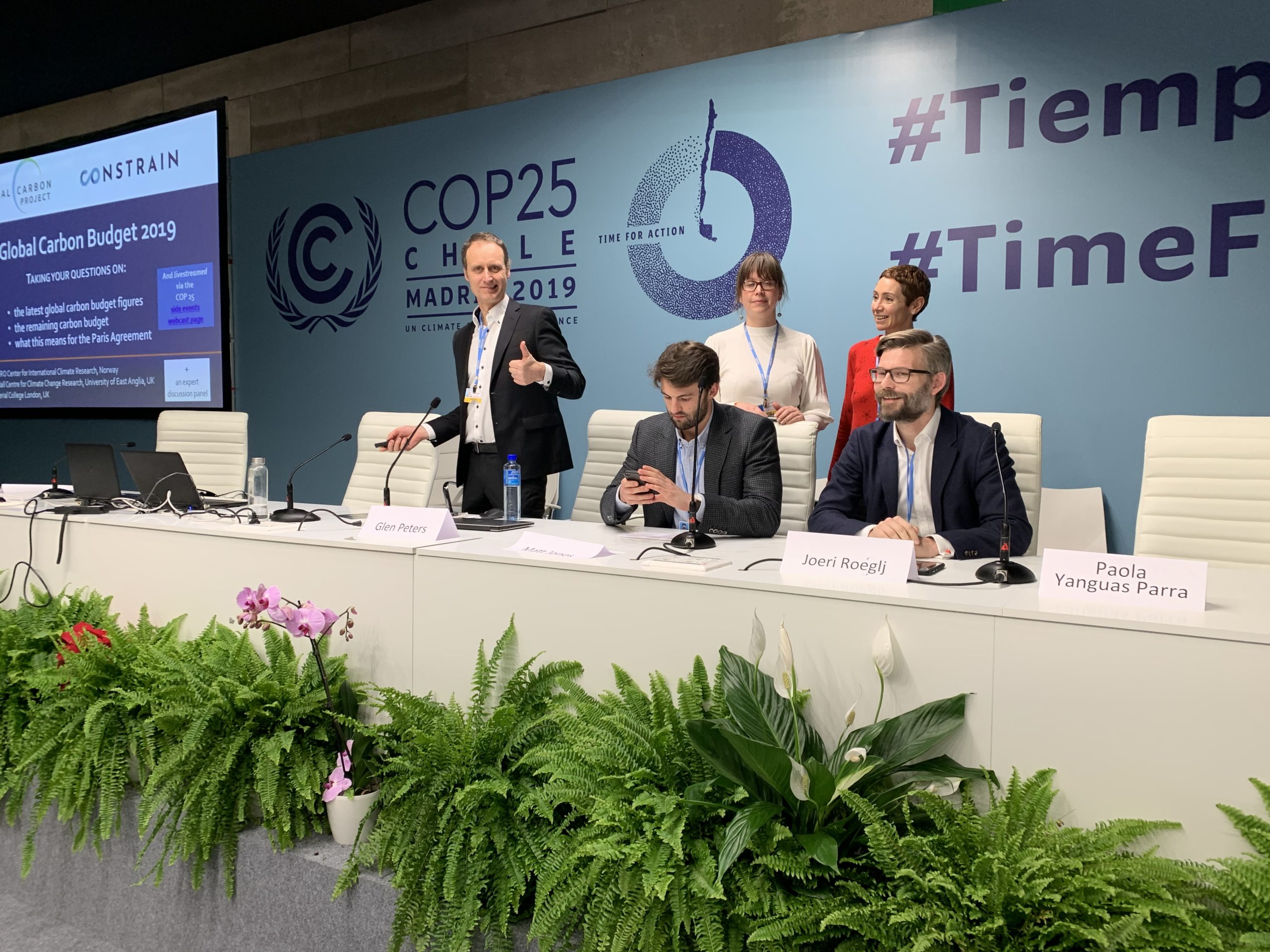 Panel of people sat at a table with microphones and slide presentation behind them at COP25 in Madrid 2019
