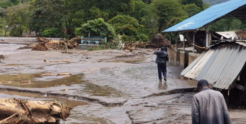 People reviewing destroyed buildings and mud landslide