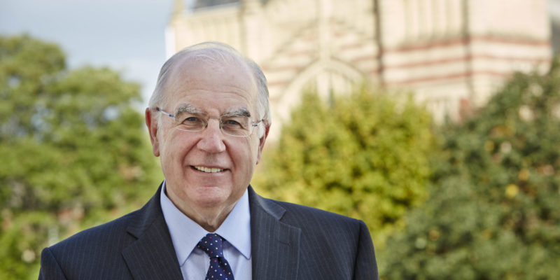 Sir Alan Langlands, Vice-Chancellor of the University of Leeds, smiles at camera with the Great Hall in the background