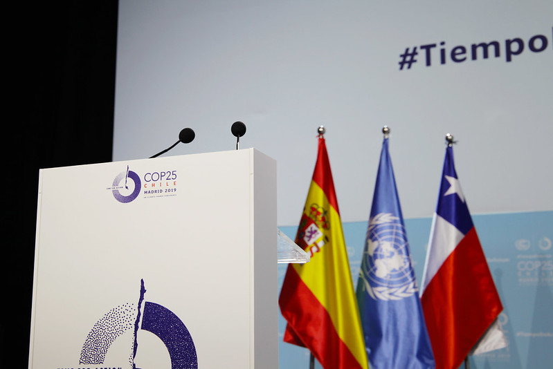 View of the podium at COP25 in Madrid, showing flags behind the podium