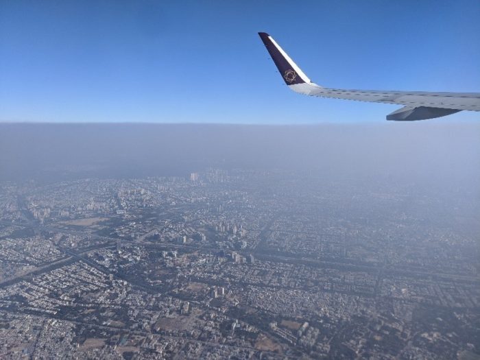 View from the window of a plane showing fog over Delhi