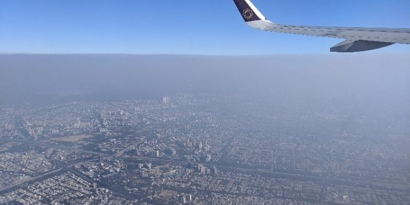View from the window of a plane showing fog over Delhi