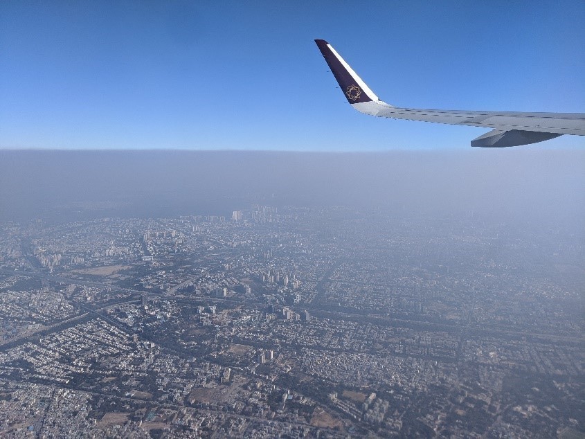 View from the window of a plane showing fog over Delhi