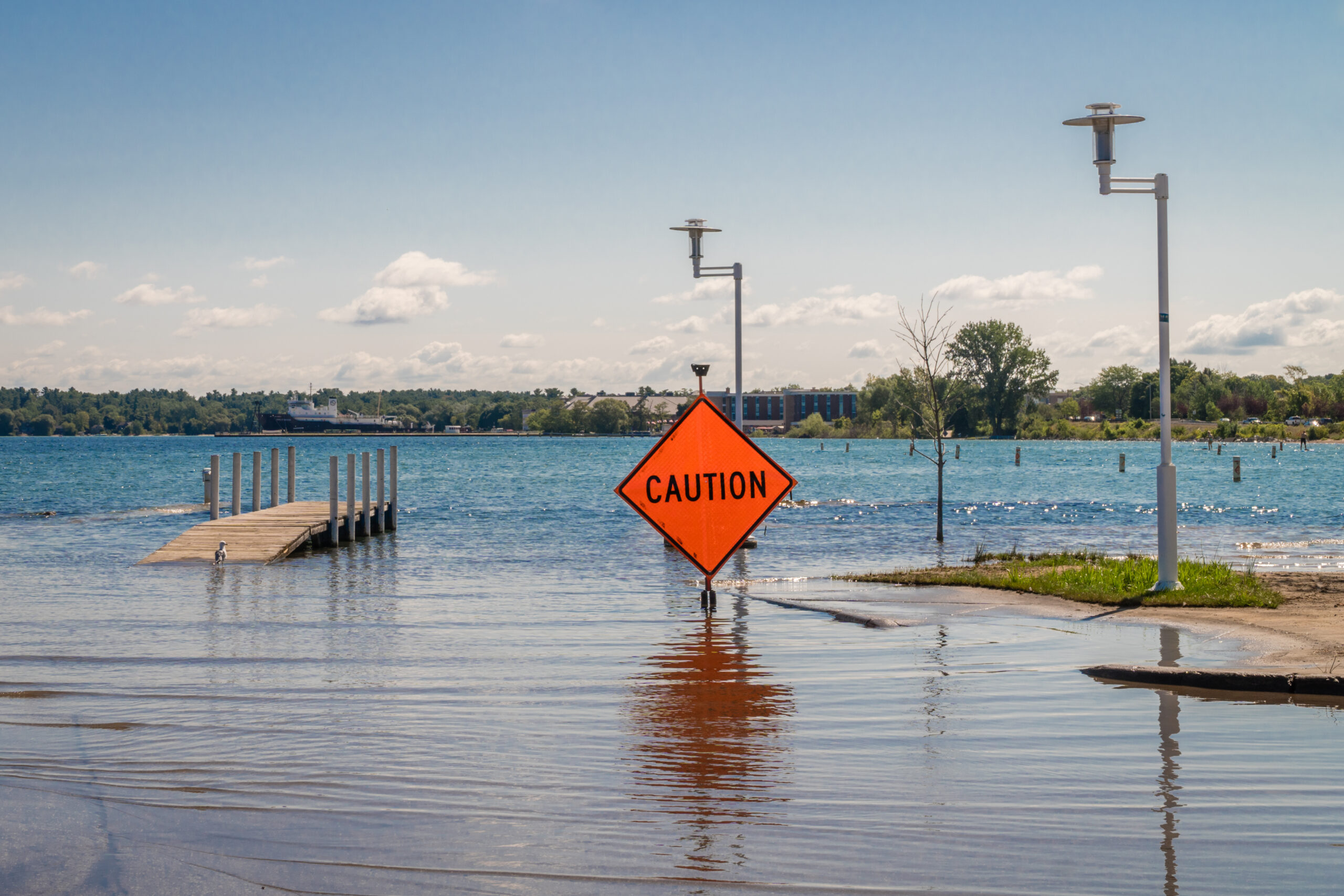 An orange 'CAUTION' sign in flood water