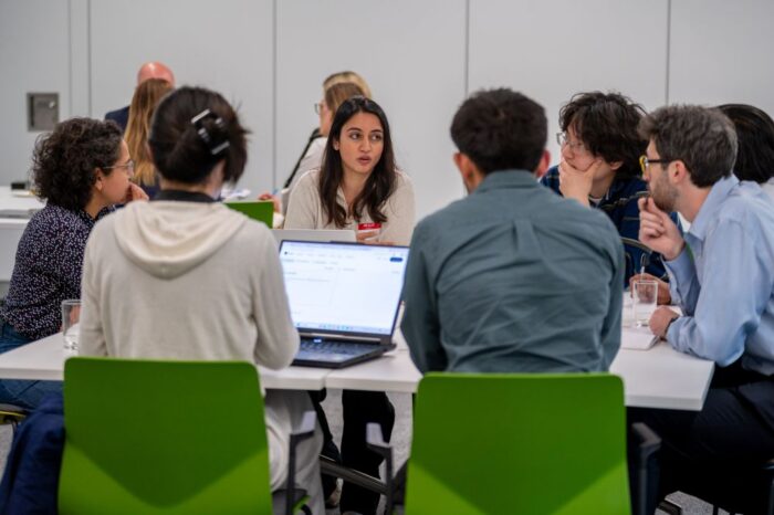 group with laptops sat around a table